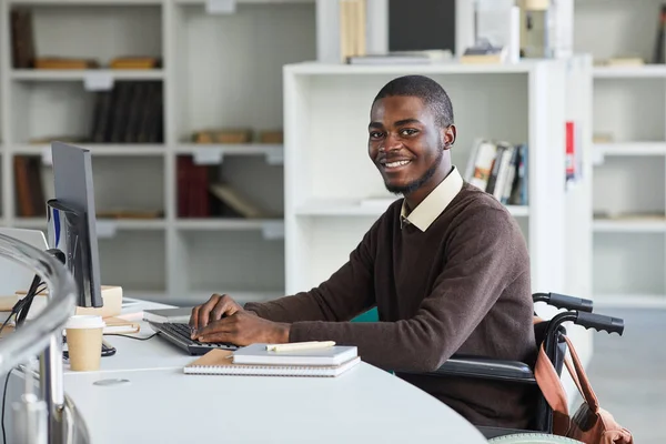 非洲裔美国残疾男子在高校图书馆学习时 用电脑对着相机笑的肖像 复制空间 — 图库照片