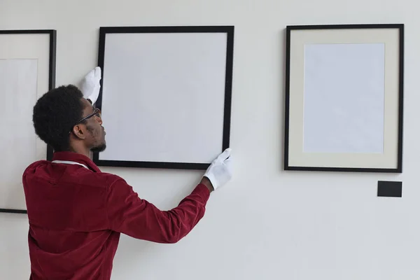 Vista Trasera Hombre Afroamericano Colgando Marcos Pared Mientras Planifica Galería —  Fotos de Stock