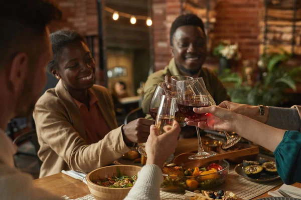 一对快乐的非洲裔美国人夫妇在舒适的室内与朋友和家人共进晚餐时碰杯的肖像 — 图库照片