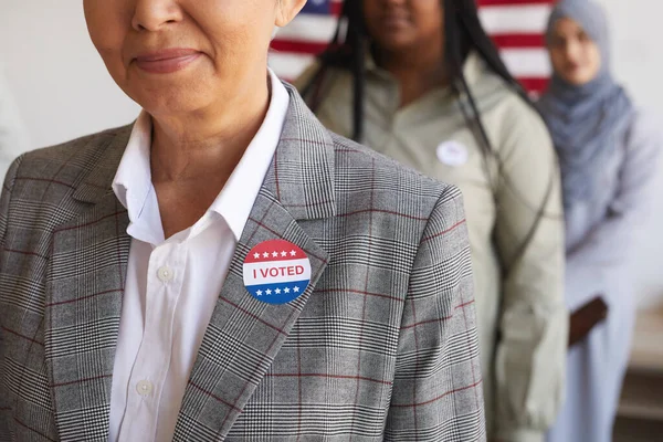 投票所の多民族集団の選挙日のイメージを切り取り 前景にI Votedステッカーで笑顔の先輩女性に焦点を当て スペースをコピー — ストック写真