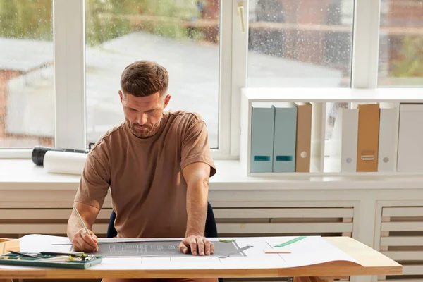 Portret Van Een Knappe Bebaarde Architect Die Blauwdrukken Bekijkt Terwijl — Stockfoto