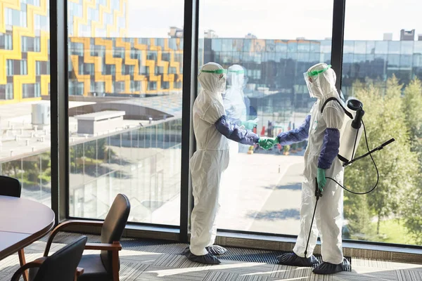 Retrato Comprimento Total Dois Trabalhadores Desinfecção Usando Ternos Hazmat Apertando — Fotografia de Stock