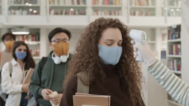 Multikulturelle Universitätsstudenten Mit Gesichtsmasken Aus Stoff Stehen Der Bibliothek Schlange — Stockvideo