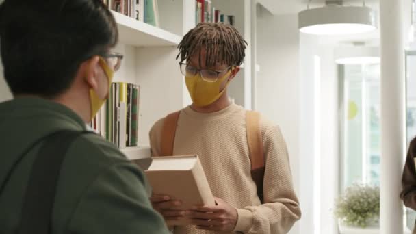 Cintura Por Cima Ombro Estudante Africano Segurando Livro Nas Prateleiras — Vídeo de Stock