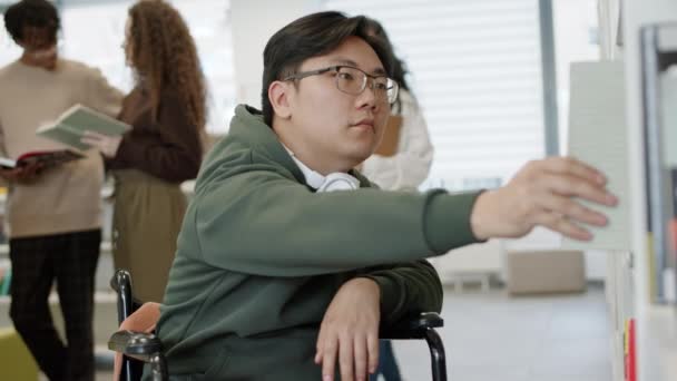 Medium Close Disabled Asian Young Man Sitting Wheelchair Taking Book — Stock Video