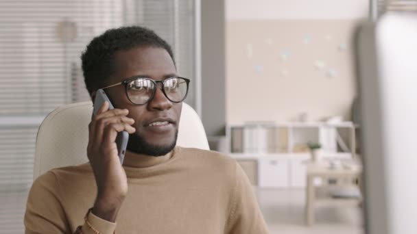 Średnie Ujęcie Młodego Afroamerykanina Biznesmena Ubraniach Okularach Siedzącego Przy Biurku — Wideo stockowe