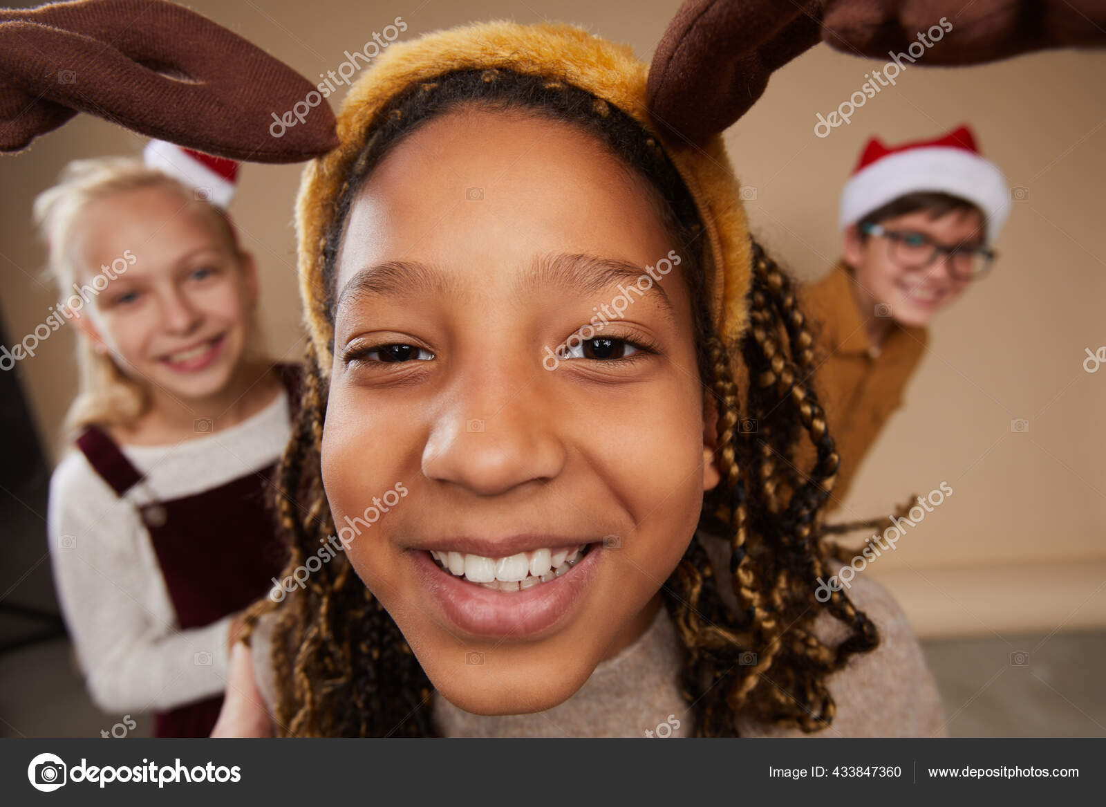 三个穿着圣诞画像站在摄影棚背对着背景站在摄像机前微笑的孩子的鱼眼画像 图库照片 C Seventyfour