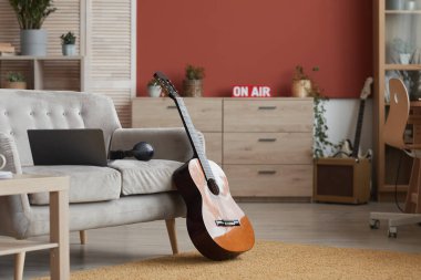 Müzik aletleriyle modern odanın arkaplan görüntüsü ve hava işareti üzerinde, ön planda gitara odaklan, boşluğu kopyala