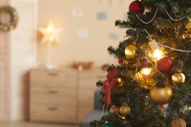 Güzel bir Noel ağacının arkaplan resmi. Evin iç kısımlarında altın süslemelerle süslenmiş. Boşluğu kopyala.