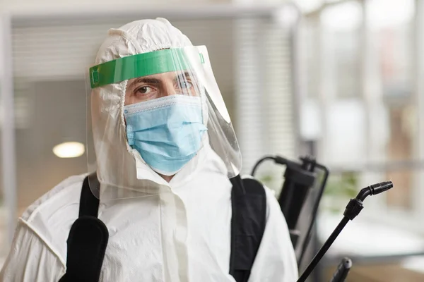 男用消毒工的画像 穿着全套防护服 在办公室清洁时看着相机 复制空间 — 图库照片