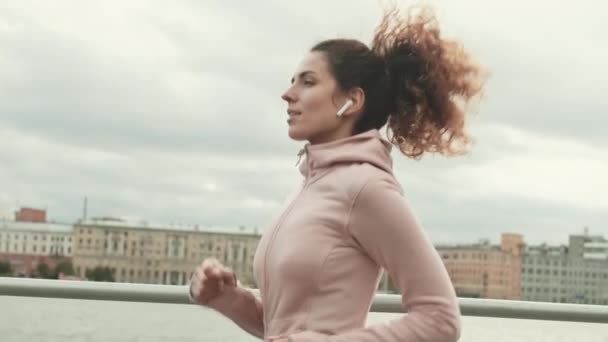 Середній Постріл Кучерявої Жінки Одягненої Спортивний Одяг Бездротові Навушники Бігають — стокове відео