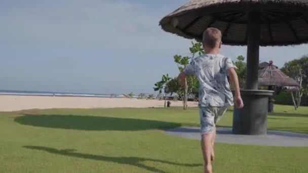Zadní Pohled Malého Bělocha Šortkách Tričku Běžící Trávníku Pláži — Stock video