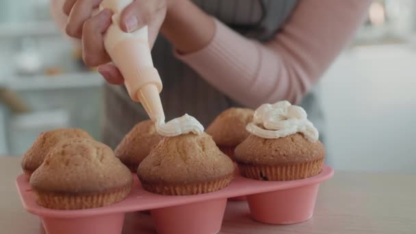 Közelkép Hat Sült Muffinról Rózsaszín Sütési Formában Amint Tejszínhabbal Töltik — Stock videók