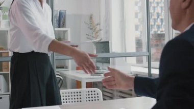 Genç Asyalı bayan adayın omzunun üzerinden tanınmaz halkla ilişkiler müdürünü selamlıyor, masada oturuyor, gülümsüyor, konuşuyor, parlak bir ofiste iş görüşmesi yapıyor.