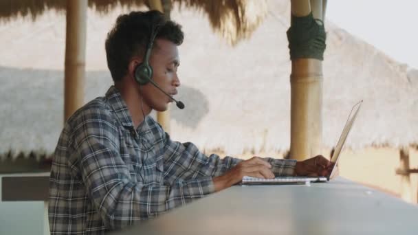 셔츠와 헤드셋을 아시아 서비스 운영자의 테라스에 노트북 비디오 연결을 고객과 — 비디오
