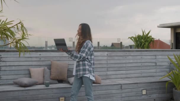 미디엄은 여성이 테라스 위에서 노트북을 비디오 링크로 친구와 의사소통하는 모습을 — 비디오
