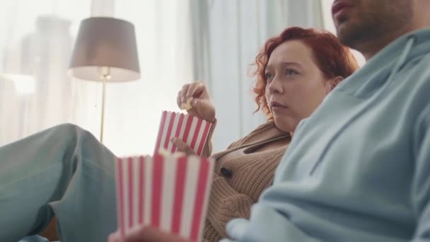Niskokątny Widok Boku Rudowłosej Białej Młodej Kobiety Jedzącej Popcorn Czerwono — Wideo stockowe
