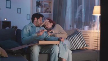 Orta uzun, melez bir adamın kutudan pizza yediği beyaz kız arkadaşının oturma odasındaki kanepenin yanında oturduğu bir yer. Görünmez film sahnesinde yaltaklanan, konuşan ve gülen çiftler