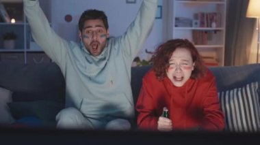 Mavili, favori takımını kutlayan, kırmızı çizgili, beyaz bir kadına bağıran, alay eden, çığlık atan, geceleri TV 'de bira şişeleriyle maç izleyen orta boy bir adam.