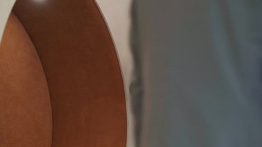 Beyaz tenli, şık takım elbiseli genç bir iş adamının koridorda dikilip iş arkadaşınla telefonda konuşurken orta boy fotoğrafı.