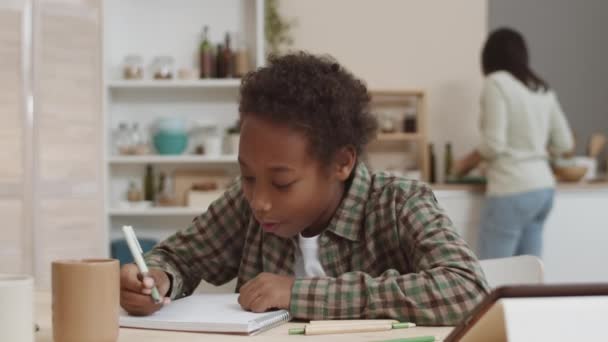 Pecho Niño Alegre Escuela Africana Sentado Mesa Casa Escribiendo Cuaderno — Vídeo de stock