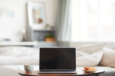 Ev içi rahat yatağın yanında kahvaltı waffle 'ları olan boş dizüstü bilgisayarın minimal arkaplan görüntüsü, boşluğu kopyala