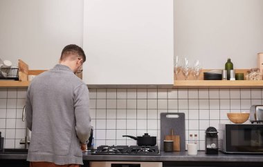 Modern yetişkin bir adamın mutfak tezgahında beklerken yemek pişirmesi için arka plan, boşluğu kopyala