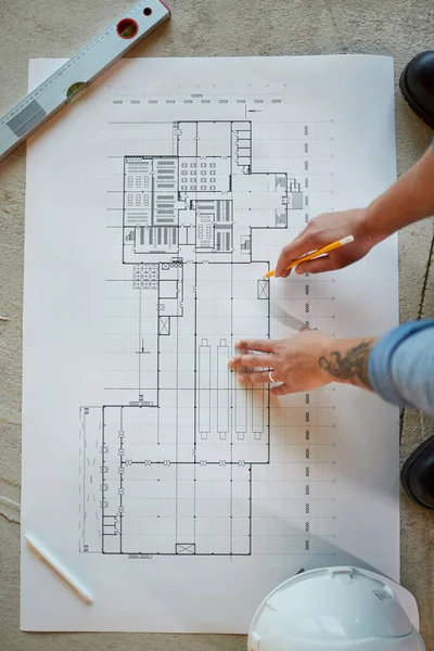 Vista Superior Cerca Trabajadora Construcción Apuntando Los Planos Mientras Trabaja —  Fotos de Stock