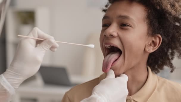 Närbild Tonårig Afrikansk Pojke Öppnar Munnen För Oigenkännlig Medicinsk Arbetare — Stockvideo