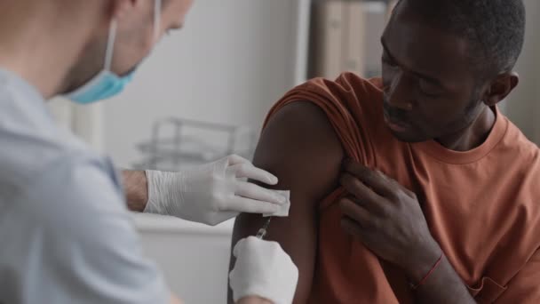 Молодий Африканець Сидить Медичному Кабінеті Тримаючи Рукав Сорочку Нерозпізнаний Лікар — стокове відео