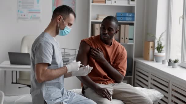 Média Longa Jovem Africano Sentado Sofá Médico Escritório Segurando Manga — Vídeo de Stock