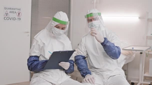 Medium Lang Van Twee Blanke Laboratoriummedewerkers Die Witte Hazmat Pakken — Stockvideo