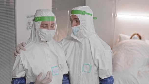 Hochgezogene Ärzte Weißen Warnanzügen Gesichtsschutz Und Masken Stehen Krankenhauszimmer Erschöpfte — Stockvideo