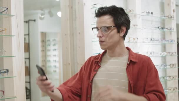 Medium Shot Attractive Caucasian Man Standing Optician Store Looking Trying — Stock Video