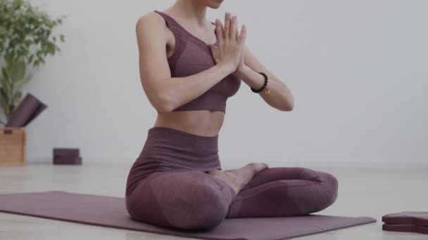 Låsning Oigenkännlig Idrottskvinna Som Bär Sportkläder Sittande Lotusställning Yogamattan Inomhus — Stockvideo
