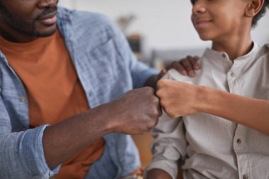 Afrikalı-Amerikalı baba ve oğul kapanış maçı kazandıktan sonra başarıyı kutlamak ve uzayı kopyalamak için yumruk tokuşturuyor.