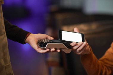 NFC ile ödeme yapan tanınmayan olgun bir adamın yan görüntüsü, telefon terminali üzerinden el ele tutuşmaya odaklan, boşluğu kopyala