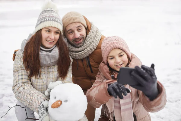 与雪人共建雪人 共度寒假的快乐家庭在户外自拍的高角肖像画 — 图库照片