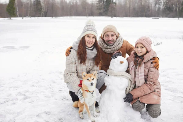 全长肖像画快乐的家庭雪人在户外共建雪人 享受寒假时看着相机 复制空间 — 图库照片