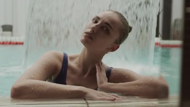 酒店游泳池里穿着蓝色游泳衣的年轻漂亮女子的中景肖像 — 图库视频影像