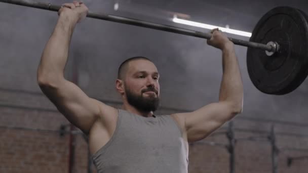 잘생긴 코카서스 스포츠맨의 운동복을 체육관에서 무거운 소리를 높이는 — 비디오
