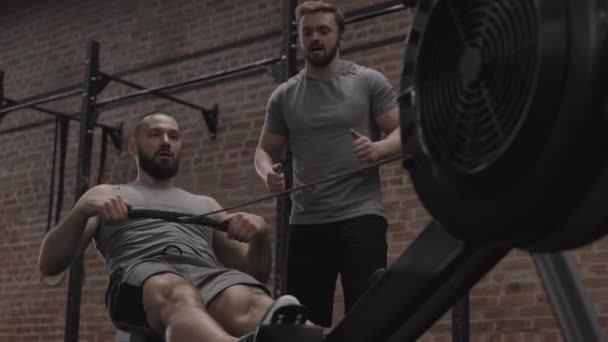 Pannning Muskulös Vit Man Sportkläder Sittande Träningsmaskin Gym Och Pumpande — Stockvideo