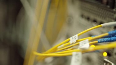 Close up of mainframe, network panel with yellow wires, different switches and indicators in data center