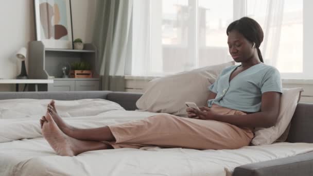 이어폰을 집에서 침대에 전화를 음악을 아프리카 여성의 — 비디오