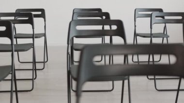 Odaklanma Gündüz vakti konferans odasına kurulmuş siyah katlanır sandalyeler