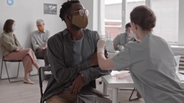 Hombre Africano Joven Con Gafas Mascarilla Sentado Sala Recepción Clínica — Vídeo de stock