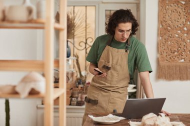 Tasarım atölyesinde dizüstü bilgisayar kullanan genç sanatçının belden yukarı portresi, küçük işletme konsepti, kopyalama alanı