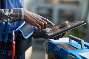 İş detaylarını koymak için dijital tablet kullanan tanınmayan Afro-Amerikan işçiyi kapat, boşluğu kopyala