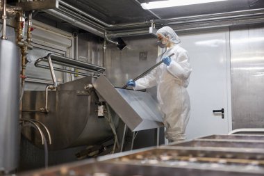 Peynir ve süt ürünlerini karıştıran genç kadın işçilerin geniş açılı portresi.