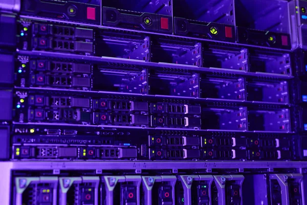 Futuristic background image of rack servers in supercomputer network lit by blue and violet light, copy space